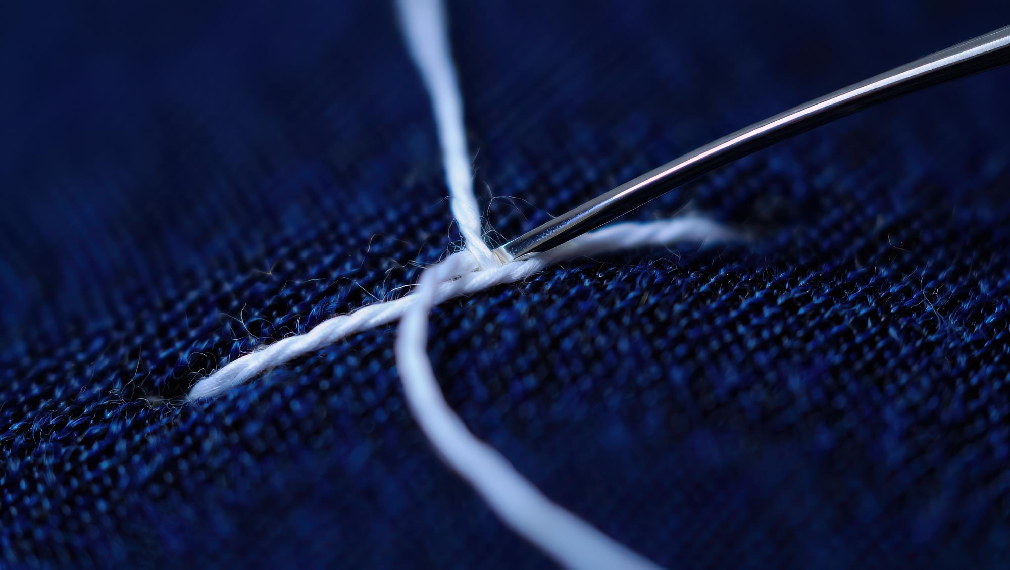 Close view of technical embroidery on fabric with metallic threads