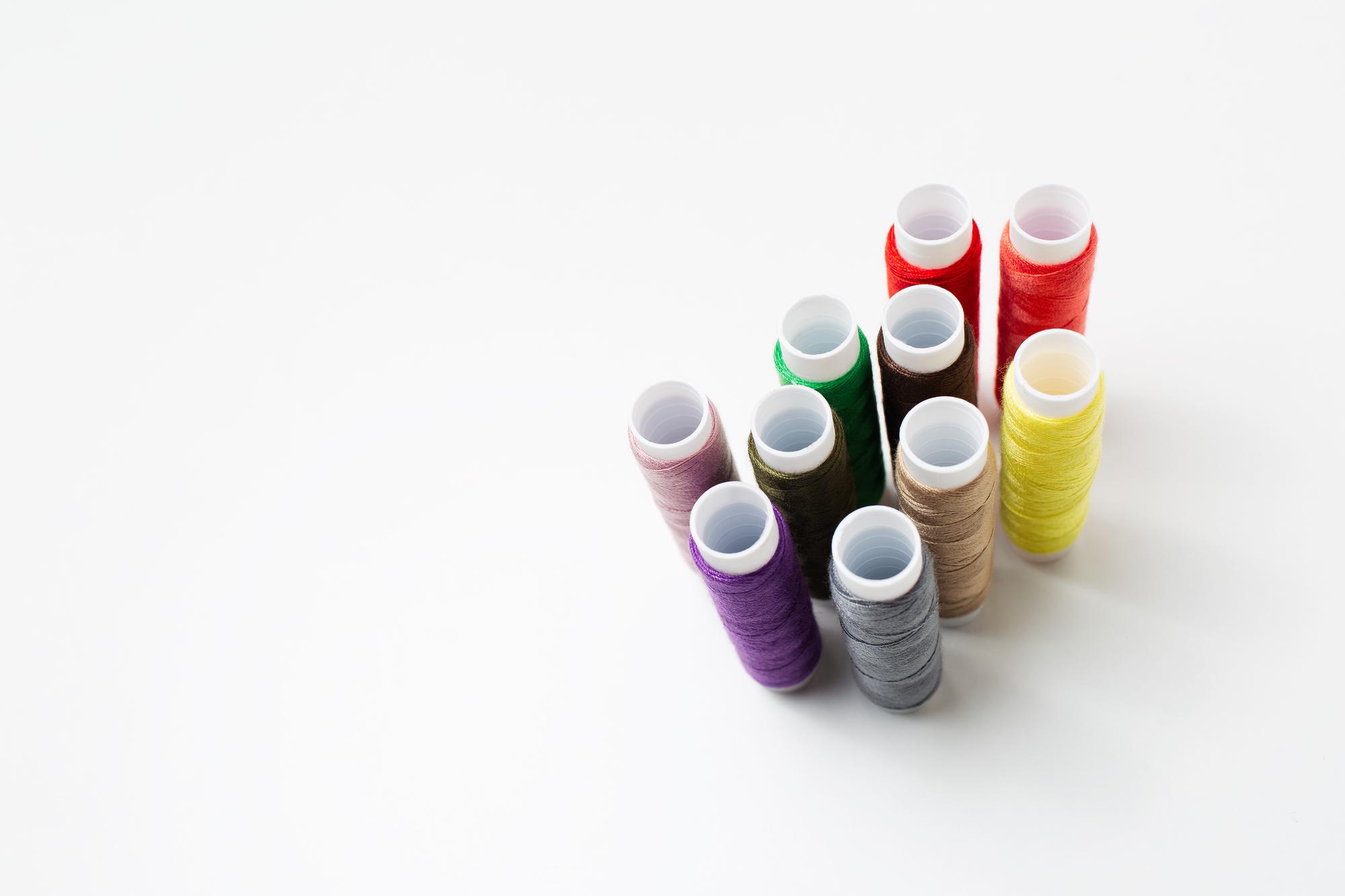 Array of threads and bobbins in studio lighting